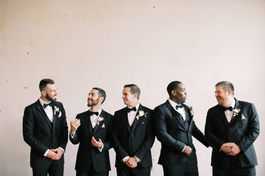 Groom and groomsmen in black tuxedos 