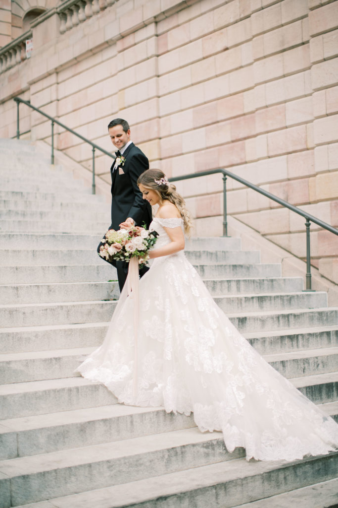 Bride and groom walking up stairs 